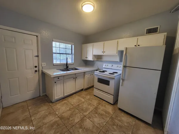 a kitchen with a stove sink and refrigerator