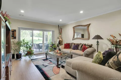 a living room with furniture a window and a flat screen tv