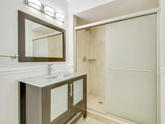 a bathroom with a shower sink and mirror