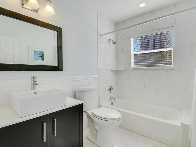 a bathroom with a toilet a sink a mirror and bathtub