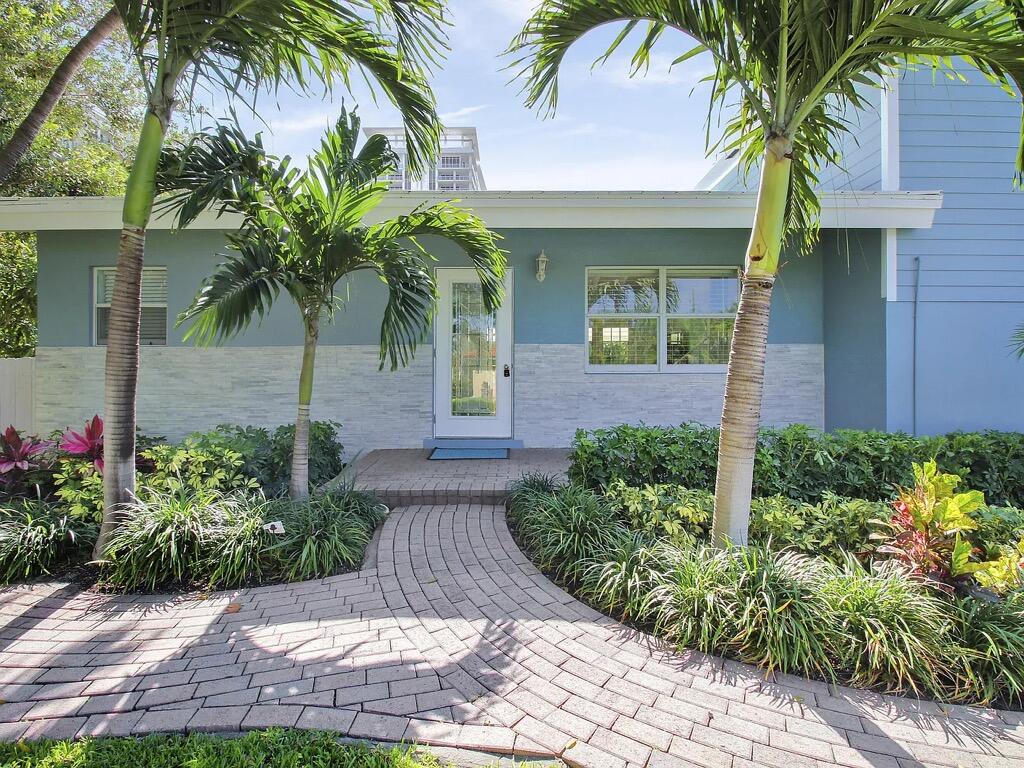 1310 Manor Drive Singer Island, FL 33404 - Photo 2 of 25 a front view of a house with a garden