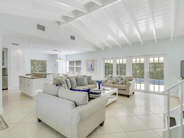 a living room with furniture and a large window with garden view