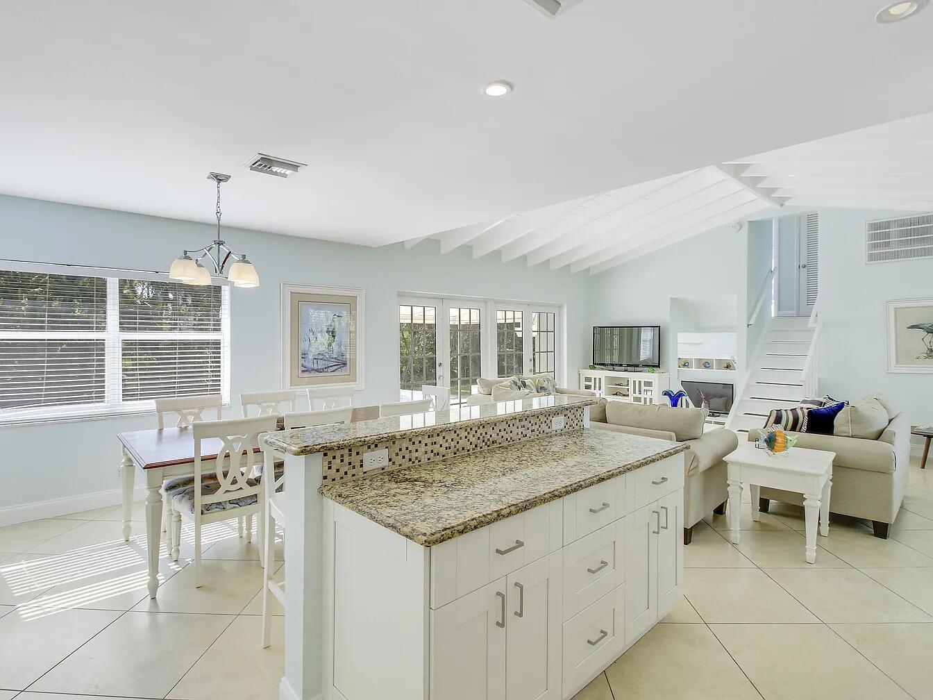1310 Manor Drive Singer Island, FL 33404 - Photo 8 of 25 a kitchen with center island table and chairs