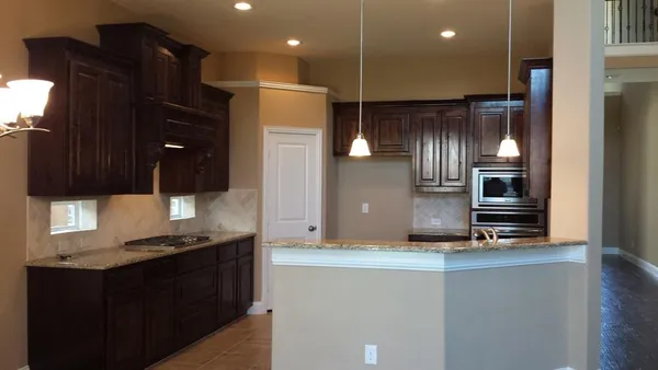 a kitchen with stainless steel appliances granite countertop a refrigerator and a stove top oven