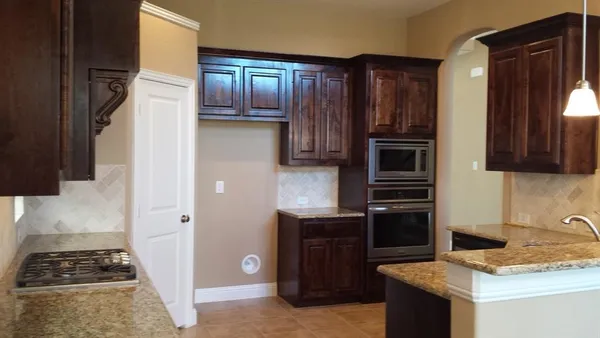 a kitchen with granite countertop stainless steel appliances and wooden cabinets