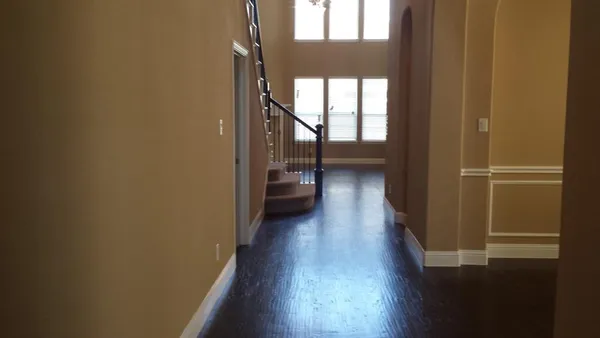 a view of a hallway with wooden floor and stairs