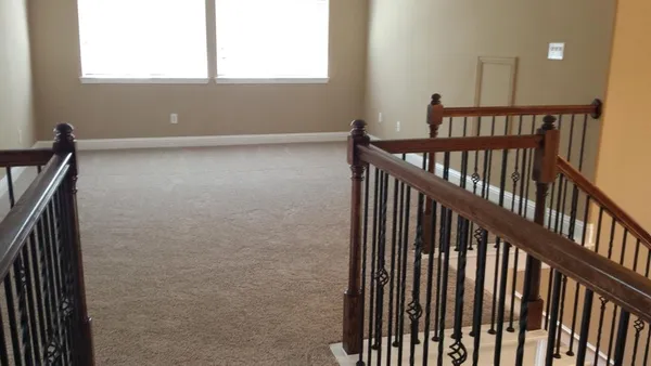 a view of staircase with railing and a window
