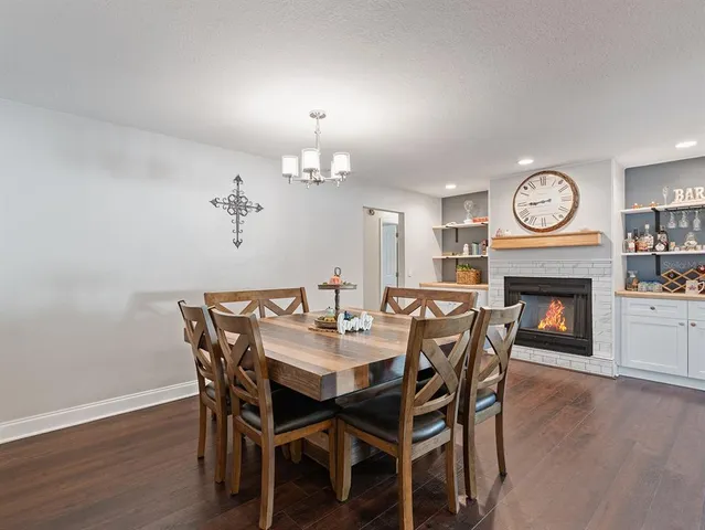 a view of a dining room with furniture a fireplace and wooden floor