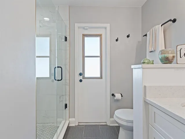 a bathroom with a granite countertop sink toilet and shower