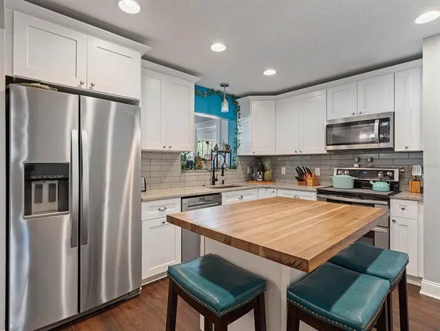 a kitchen with stainless steel appliances a refrigerator a stove a sink and a refrigerator