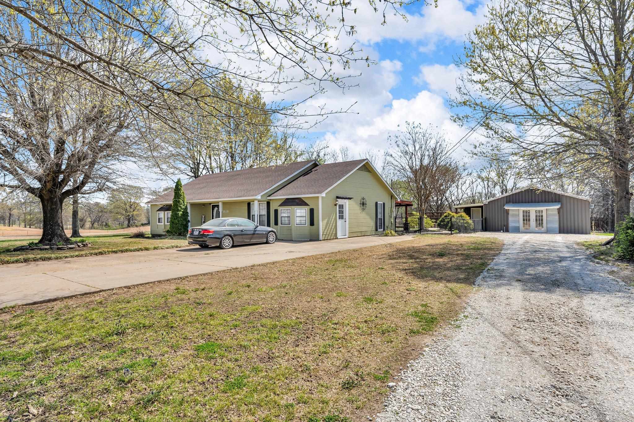 Single story home with french doors, concrete driveway, and a front lawn
