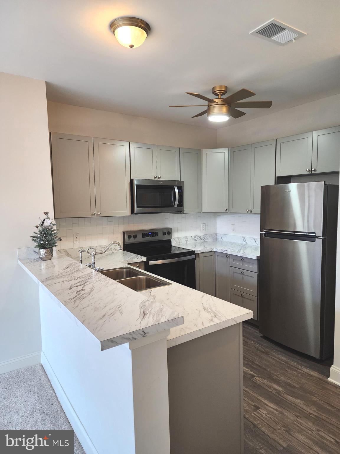 3000 Fountainview Circle, Unit 3411 Newark, DE 19713 - Photo 9 of 35 a kitchen with kitchen island granite countertop a sink stainless steel appliances and cabinets