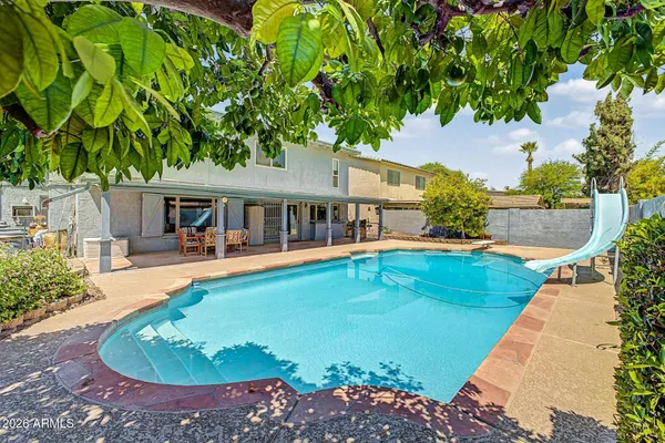 a view of house with swimming pool outdoor seating