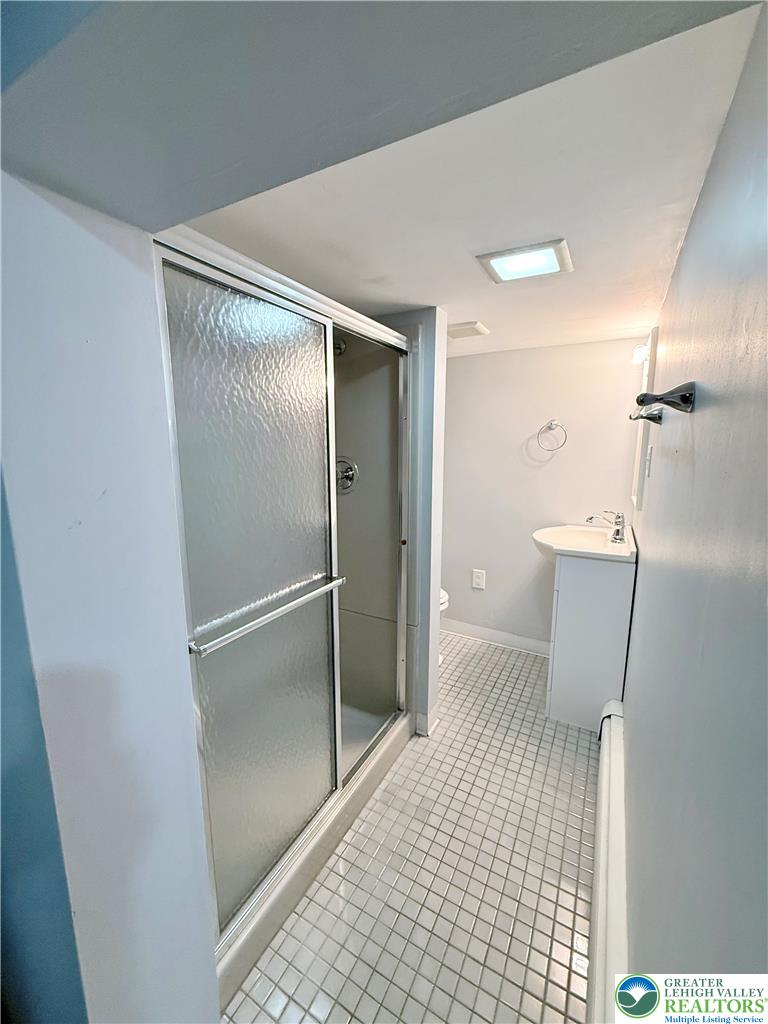 5540 Main Street Whitehall, PA 18052 - Photo 44 of 53 A well-appointed bathroom features a glass-enclosed shower and crisp tile flooring.