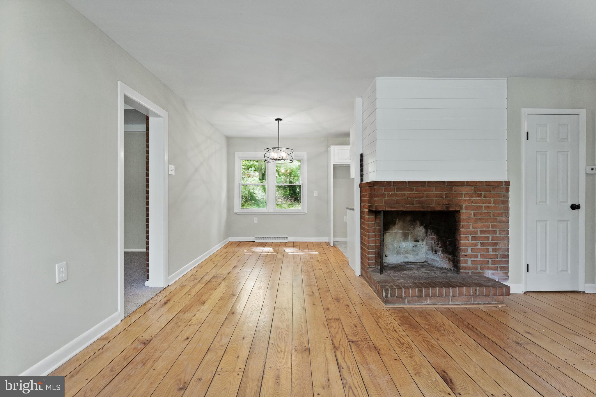 98 Wanner Road Reading, PA 19606 - Photo 12 of 30 an empty room with wooden floor fireplace and windows
