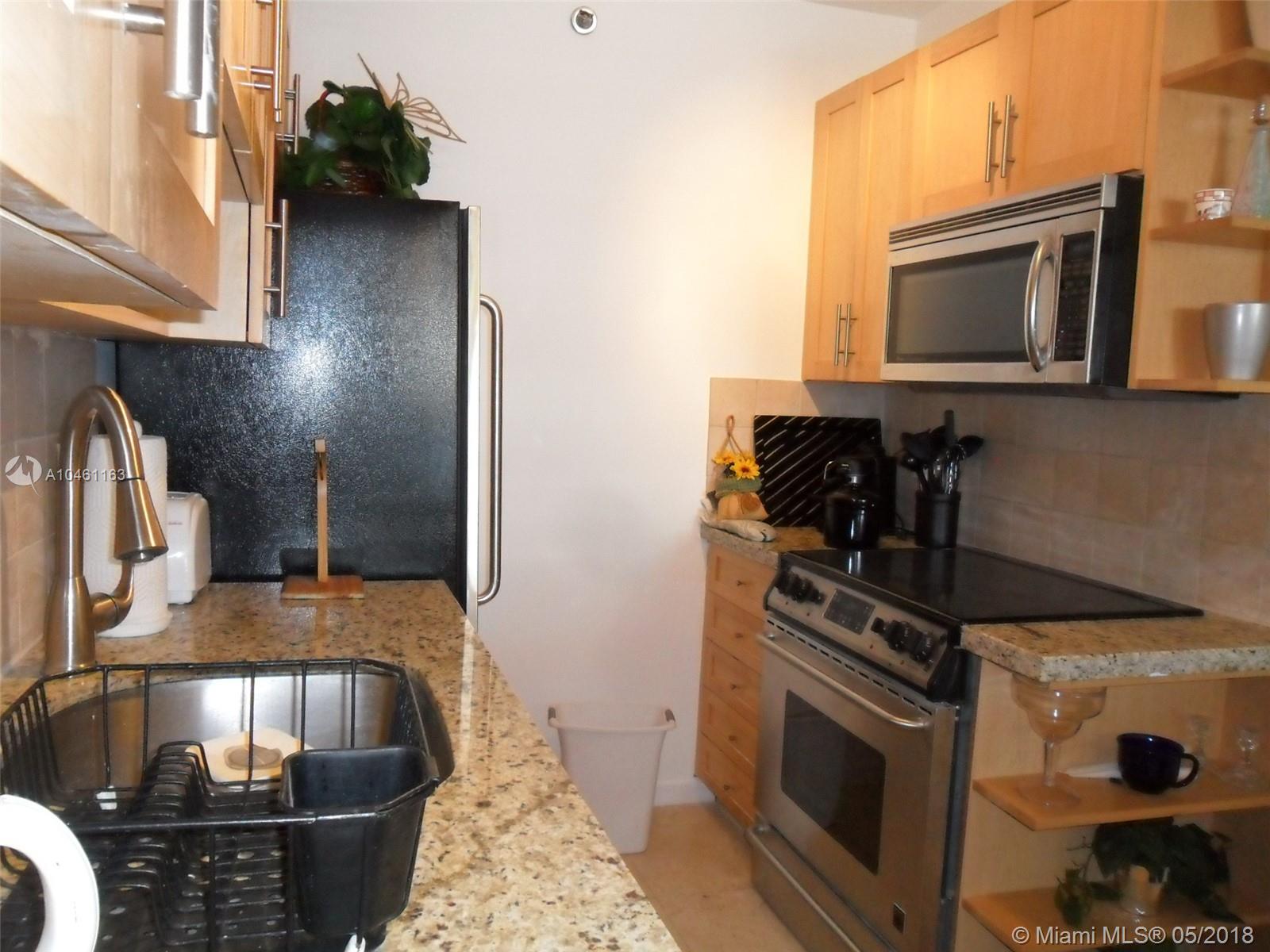 100 Lincoln Road, Unit 1243 Miami Beach, FL 33139 - Photo 7 of 12 a kitchen with a stove and a microwave