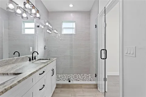 a bathroom with a granite countertop sink a shower and a mirror