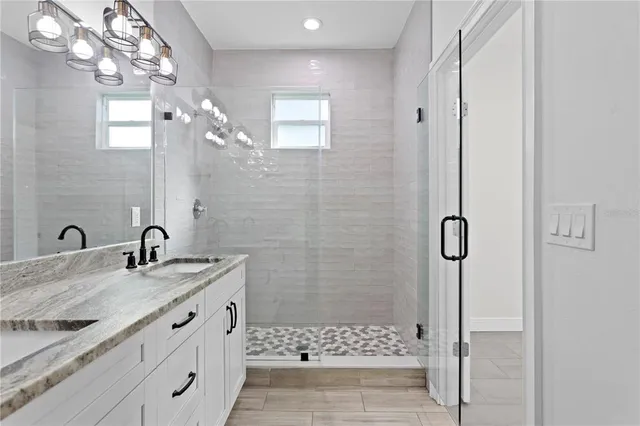 a bathroom with a granite countertop sink a shower and a mirror