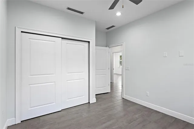 an empty room with wooden floor and cabinet