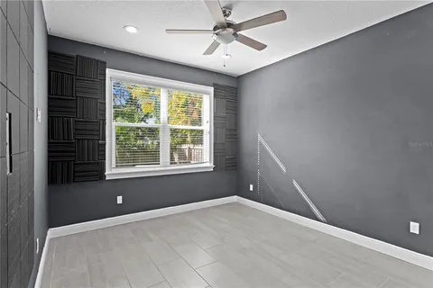 an empty room with a window and a fan