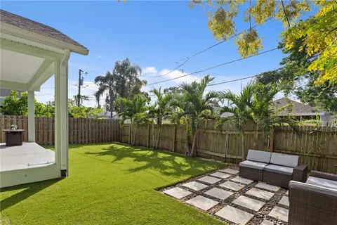 a view of a backyard with couches chair and wooden fence
