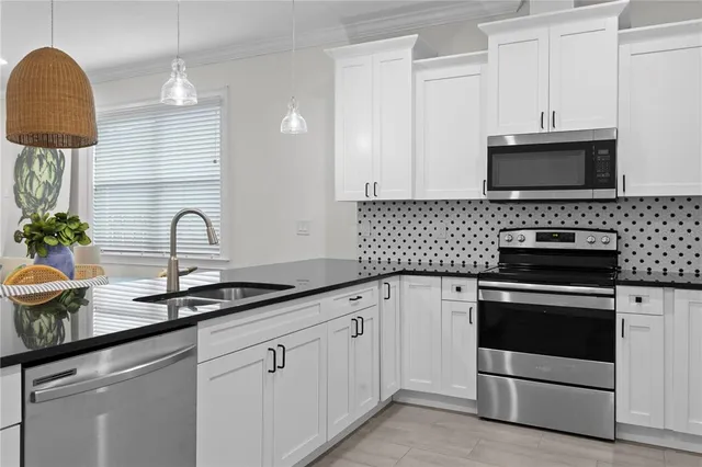 a kitchen with white cabinets and appliances