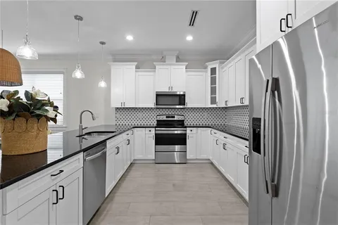 a kitchen with granite countertop a refrigerator and a sink