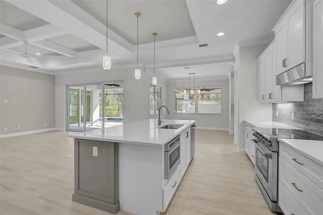 an open kitchen with kitchen island a sink stove and oven