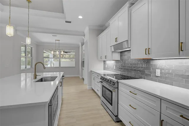 a kitchen with stainless steel appliances granite countertop a sink stove and cabinets