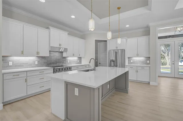 a kitchen with kitchen island a white cabinets and refrigerator