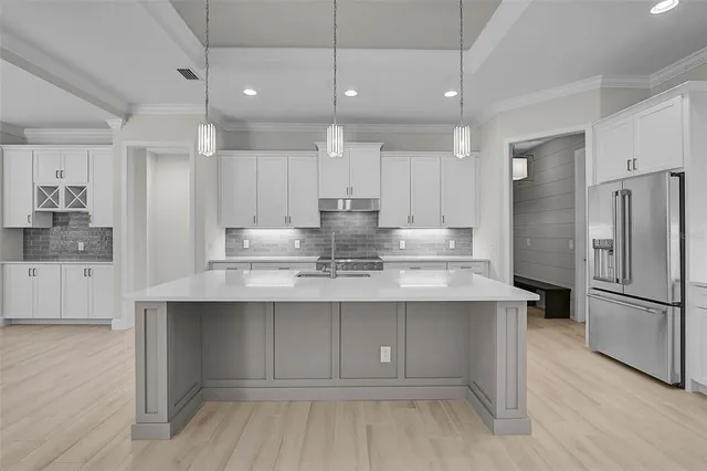 a kitchen with kitchen island a sink stainless steel appliances and cabinets