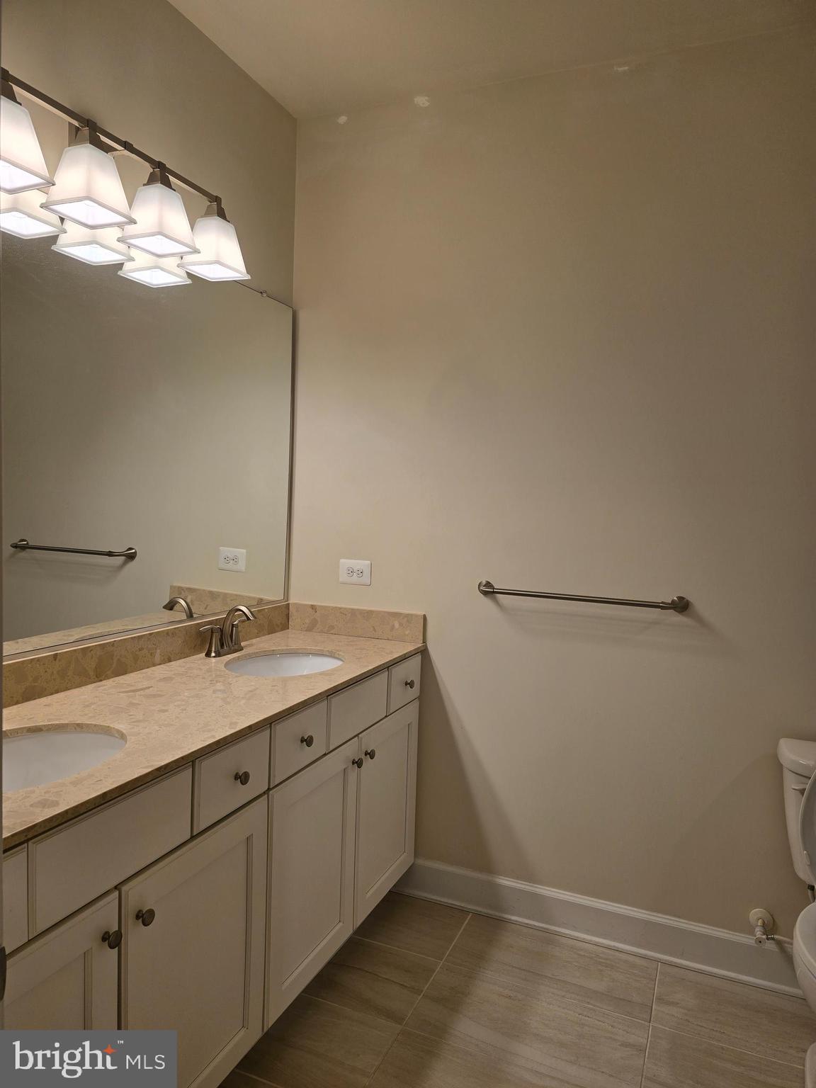 10530 Resort Road, Unit 101 Ellicott City, MD 21042 - Photo 11 of 13 a bathroom with a double vanity sink and a toilet
