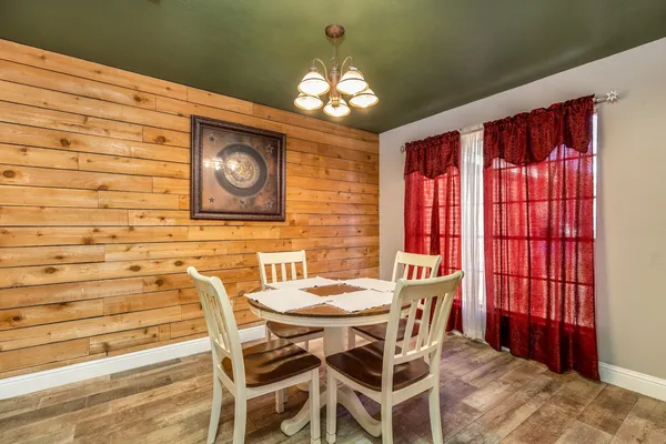a view of a dining room with furniture and a chandelier