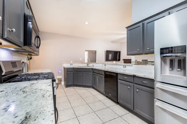 a kitchen with stainless steel appliances granite countertop a sink stove and cabinets