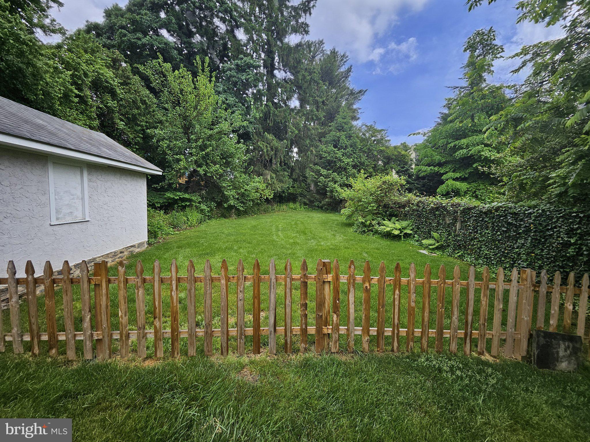 6 Arthur Road, Unit FRONT Rosemont, PA 19010 - Photo 23 of 24 Lush green retreat with rustic fence.