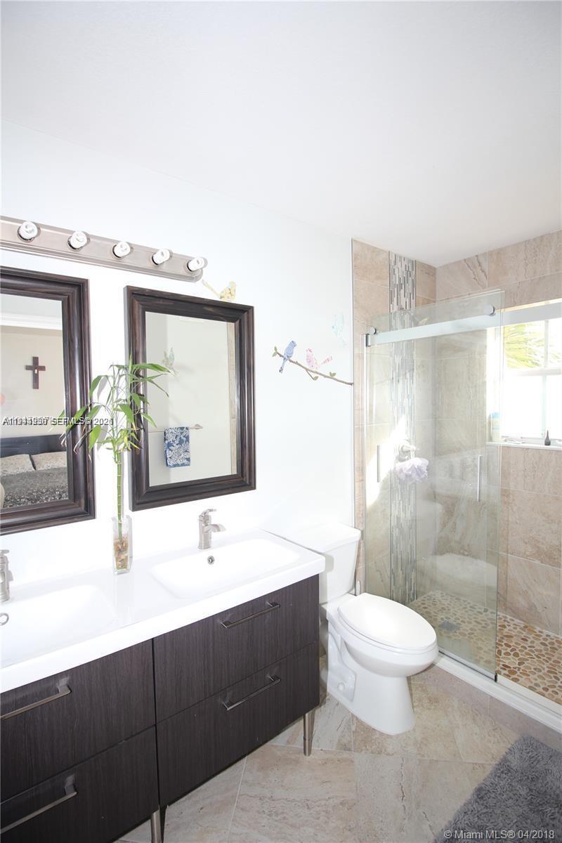 12902 Southwest 30th Street, Unit 133 Miramar, FL 33027 - Photo 12 of 16 a bathroom with a sink a toilet and shower