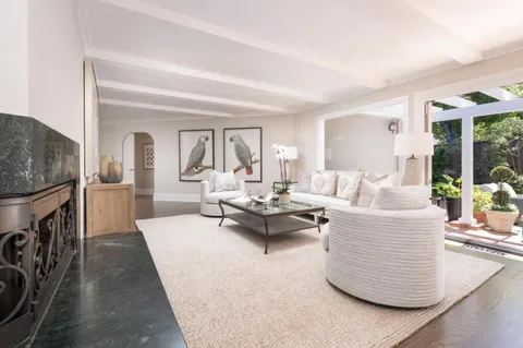 a living room with furniture a flat screen tv and a large window