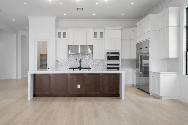 a kitchen with stainless steel appliances a refrigerator and a stove top oven