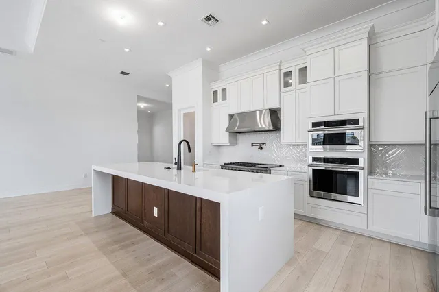 a kitchen with stainless steel appliances a stove sink and refrigerator