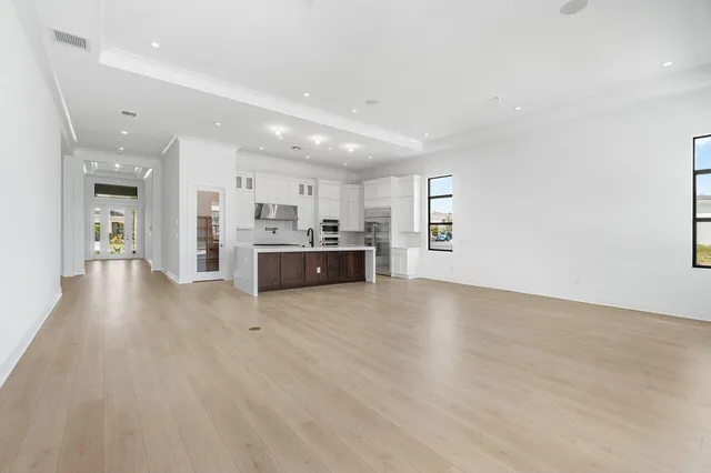 a view of a big room with wooden floor and windows