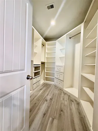 a view of a room with an empty space and wooden floor