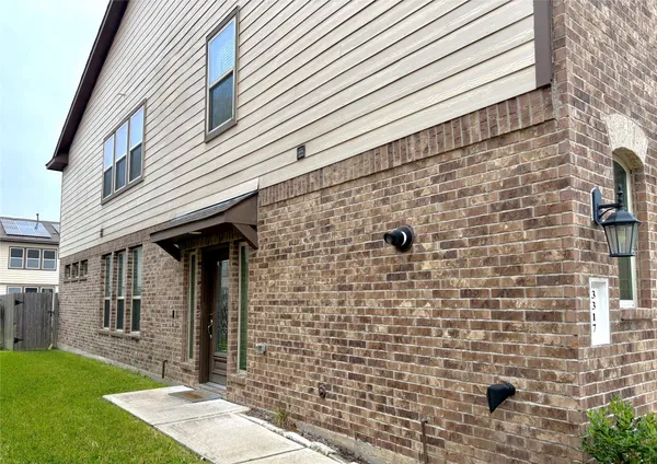 a view of a brick house with a yard