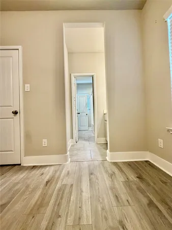 a view of a room with wooden floor and a hallway