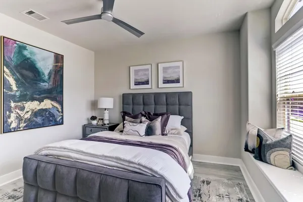 a bedroom with bed and wall painting with wooden floor