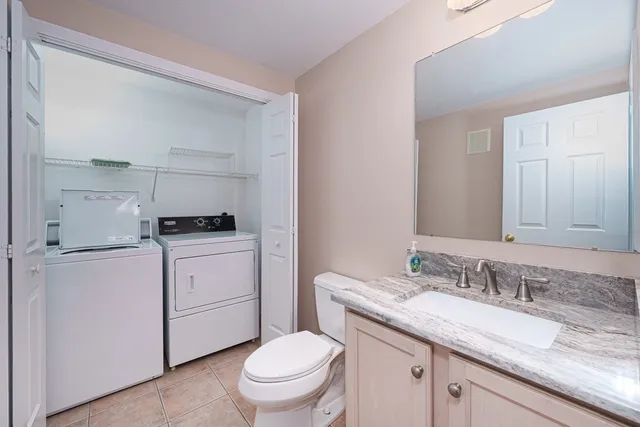 a bathroom with a granite countertop toilet sink and mirror