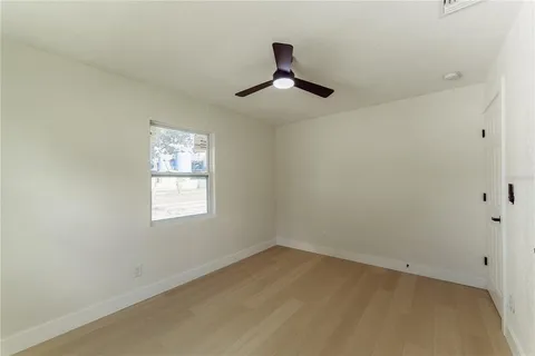 a bedroom with a large bed and wooden floor