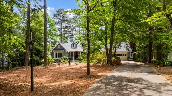 a front view of a house with a yard and trees