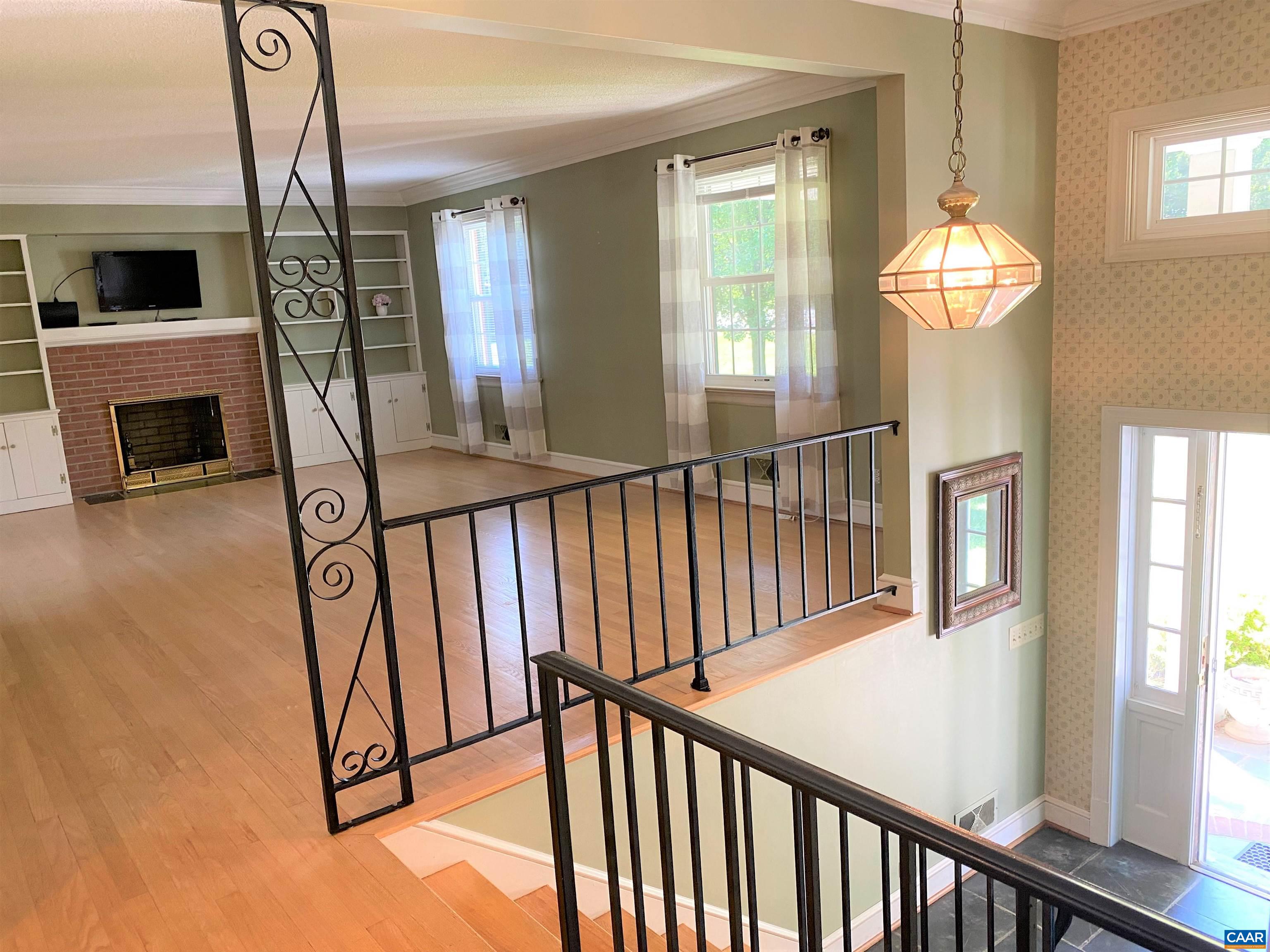 2401 Northfield Road Charlottesville, VA 22901 - Photo 6 of 23 a view of a livingroom with wooden floor fireplace and windows