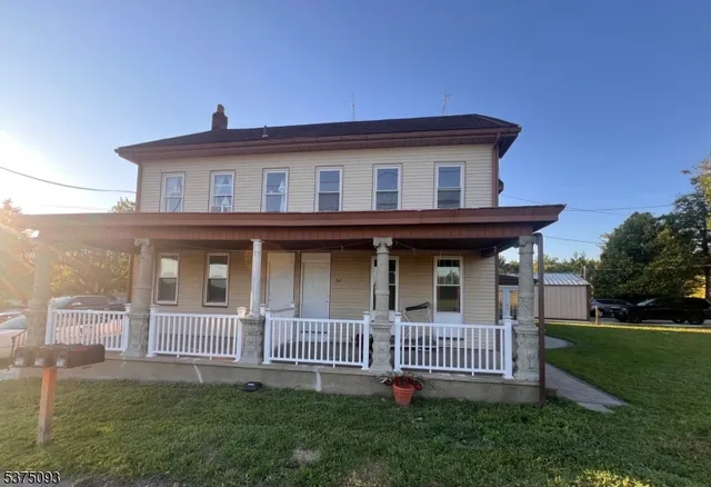 a view of a house with a small yard and a garden