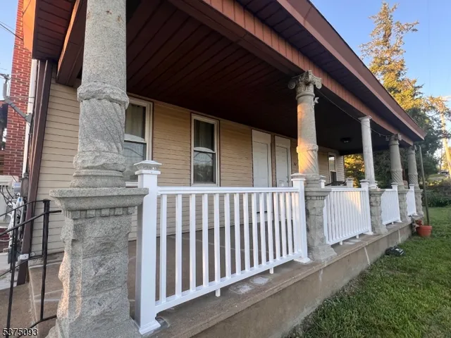 a view of a house with a small yard and wooden floor and fence